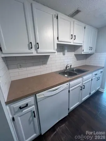 a kitchen with granite countertop white cabinets and white appliances