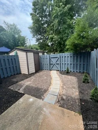 a view of backyard with small cabin and wooden fencing