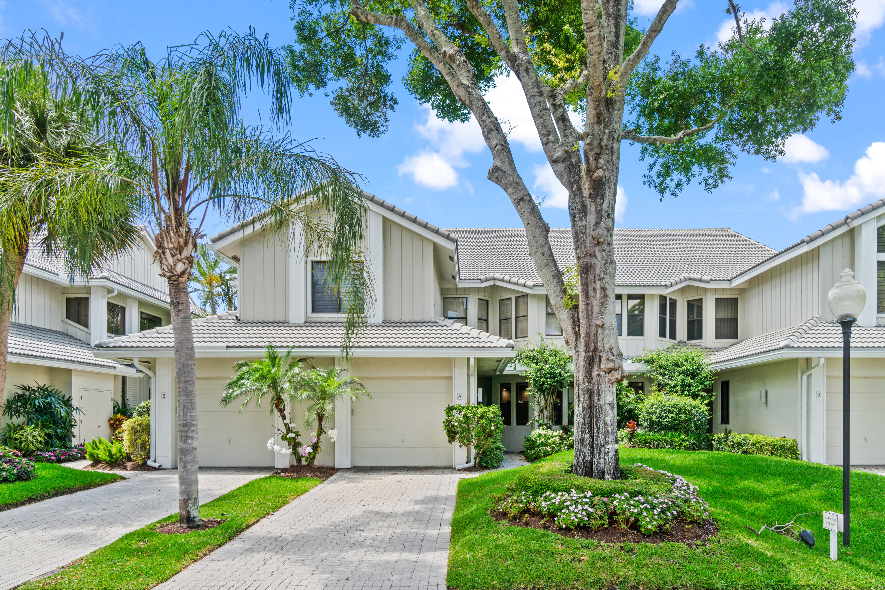 17629 Ashbourne Lane, Unit A Boca Raton, FL 33496 - Photo 35 of 35 a front view of a house with a garden and trees