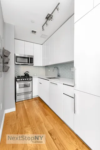 a kitchen with kitchen island white cabinets and white appliances