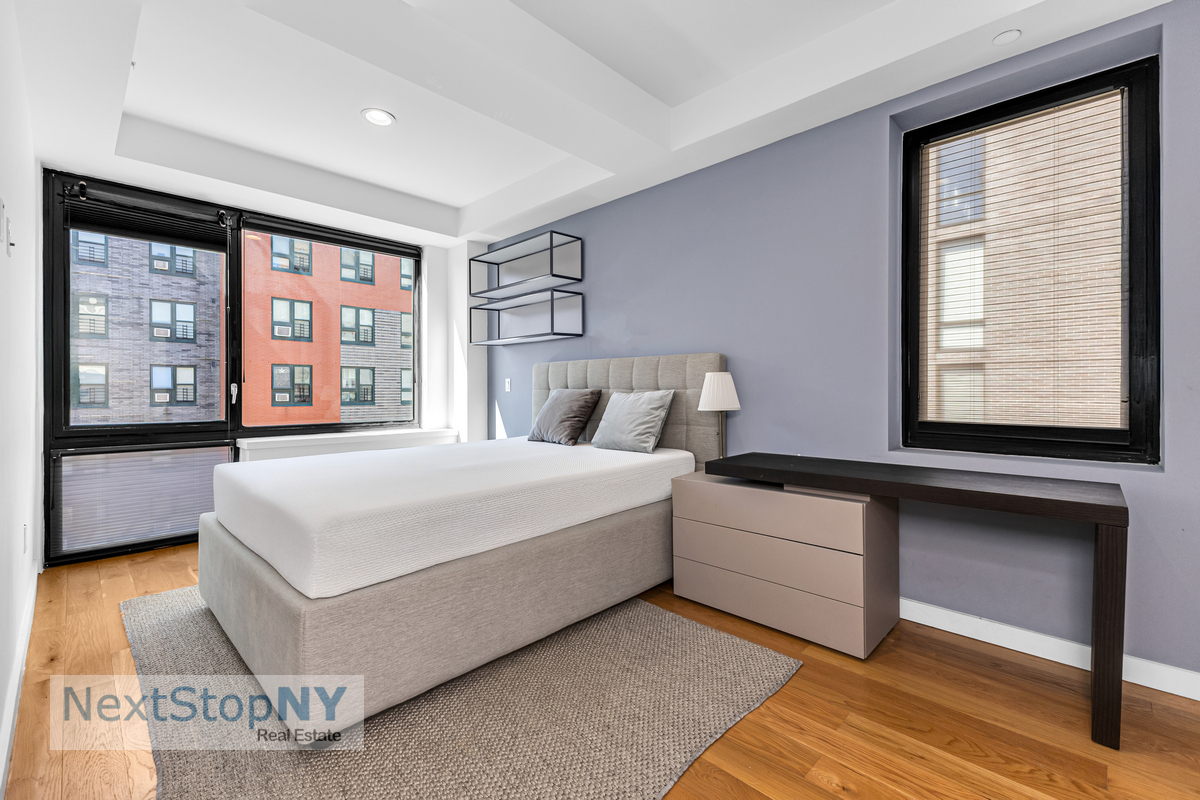 48 East 132nd Street, Unit 5C Manhattan, NY 10037 - Photo 6 of 10 a bedroom with a large bed and a large window