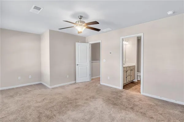 a view of an empty room with chandelier fan and a window