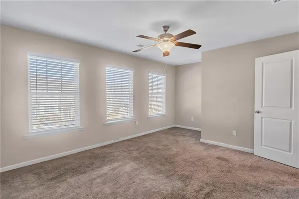 an empty room with a bathroom and a ceiling fan
