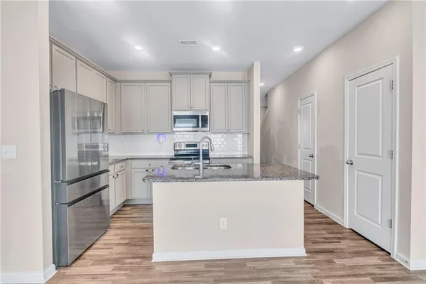 a kitchen with cabinets appliances a sink and a counter top space