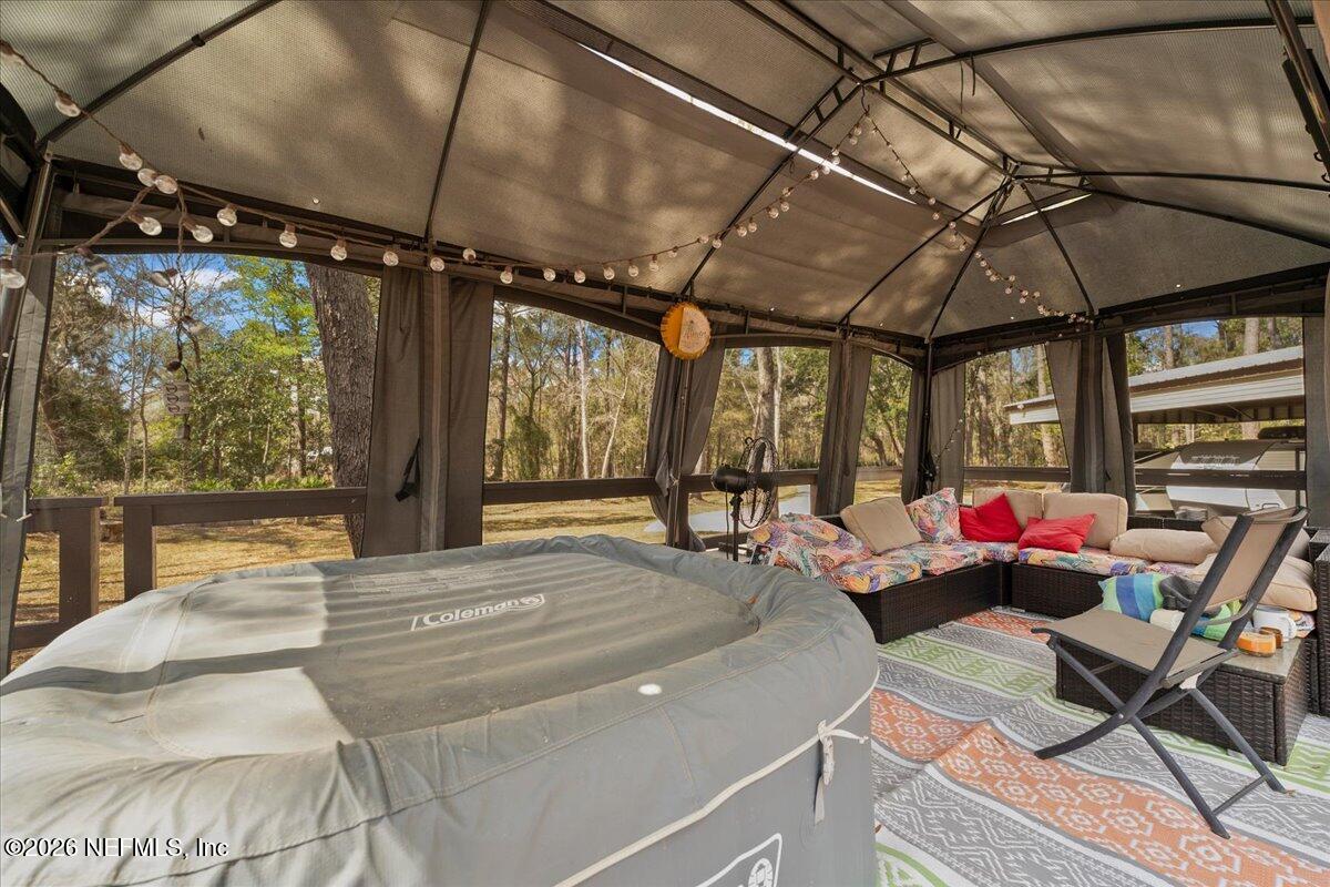 4229 Lazy Acres Road Middleburg, FL 32068 - Photo 23 of 41 a view of a patio with a table and chairs under an umbrella