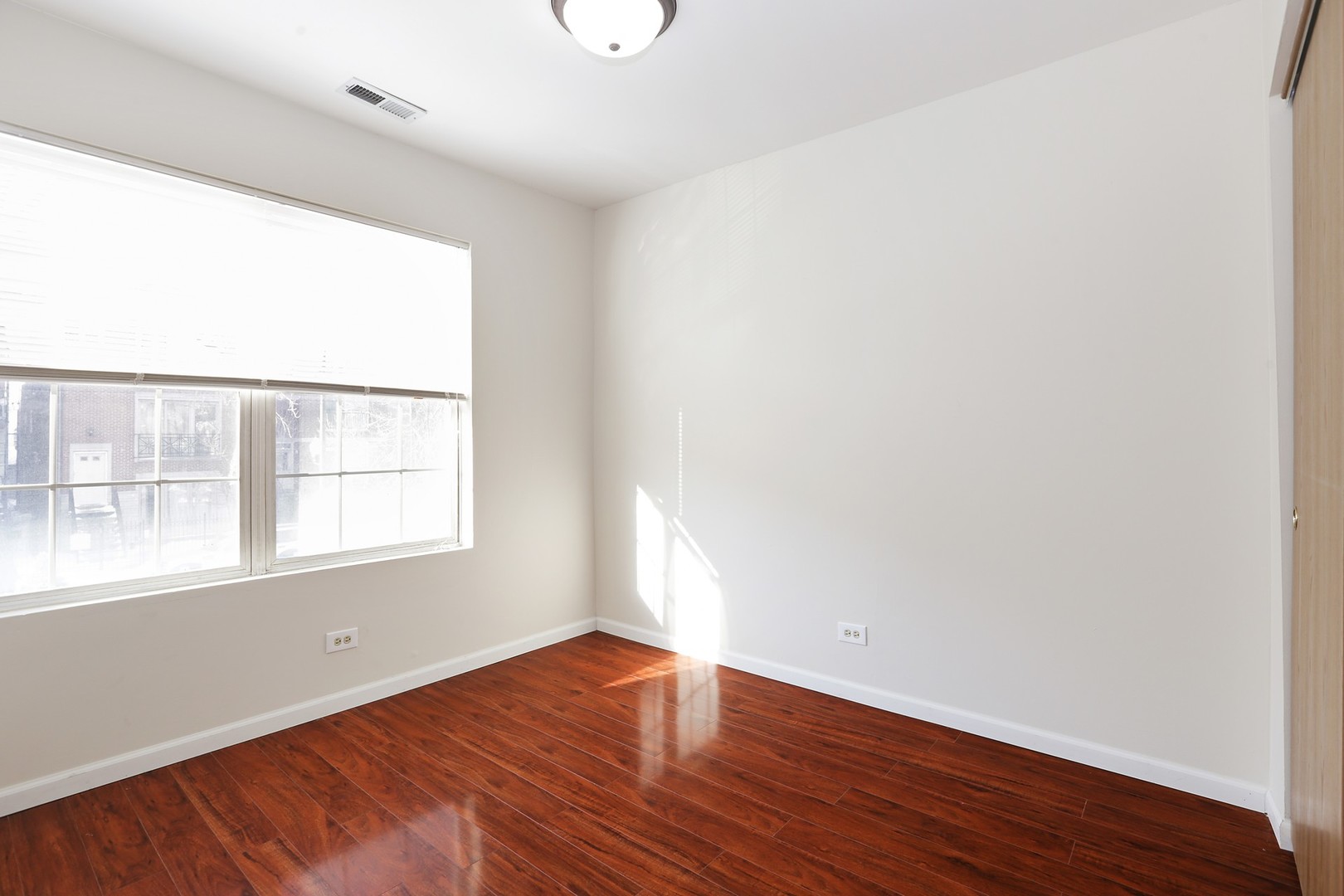 2414 West Harrison Street, Unit E Chicago, IL 60612 - Photo 12 of 15 an empty room with wooden floor and windows