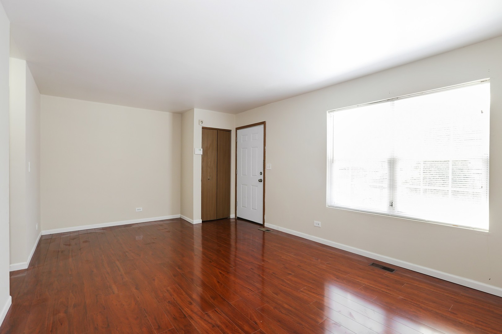2414 West Harrison Street, Unit E Chicago, IL 60612 - Photo 4 of 15 an empty room with wooden floor and windows