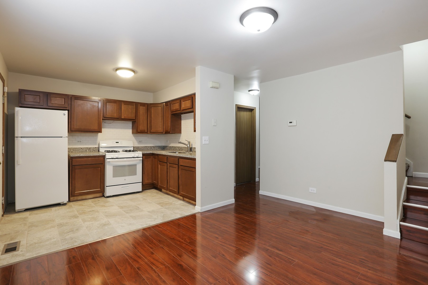 2414 West Harrison Street, Unit E Chicago, IL 60612 - Photo 6 of 15 a kitchen with a refrigerator and a stove top oven