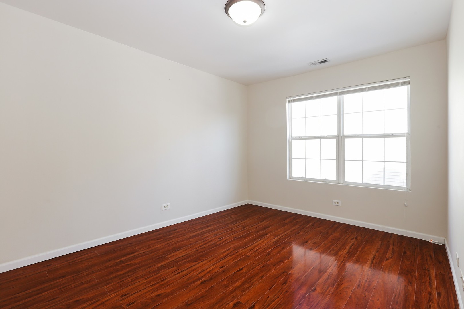 2414 West Harrison Street, Unit E Chicago, IL 60612 - Photo 9 of 15 an empty room with wooden floor and windows