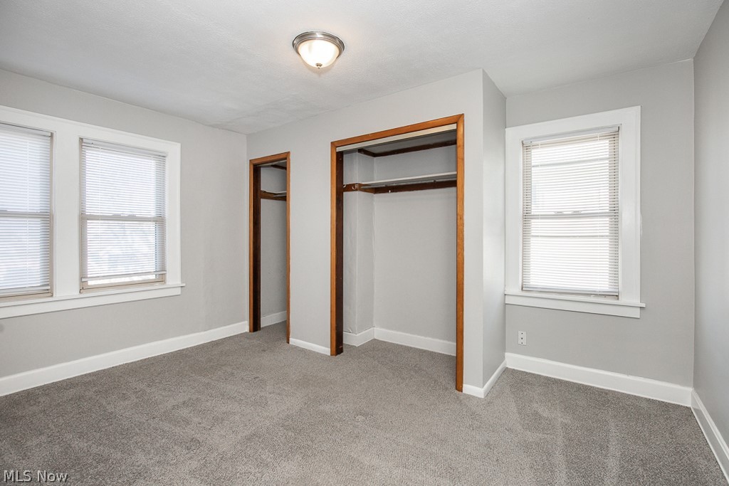 4661 Horton Road Cleveland, OH 44125 - Photo 16 of 27 Unfurnished bedroom featuring carpet, multiple windows, and a closet