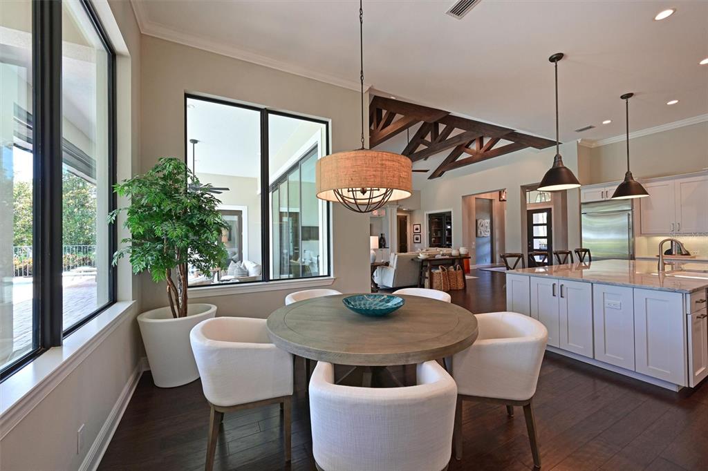 11807 Rive Isle Run Parrish, FL 34219 - Photo 14 of 57 a dining room with furniture a floor to ceiling window and wooden floor