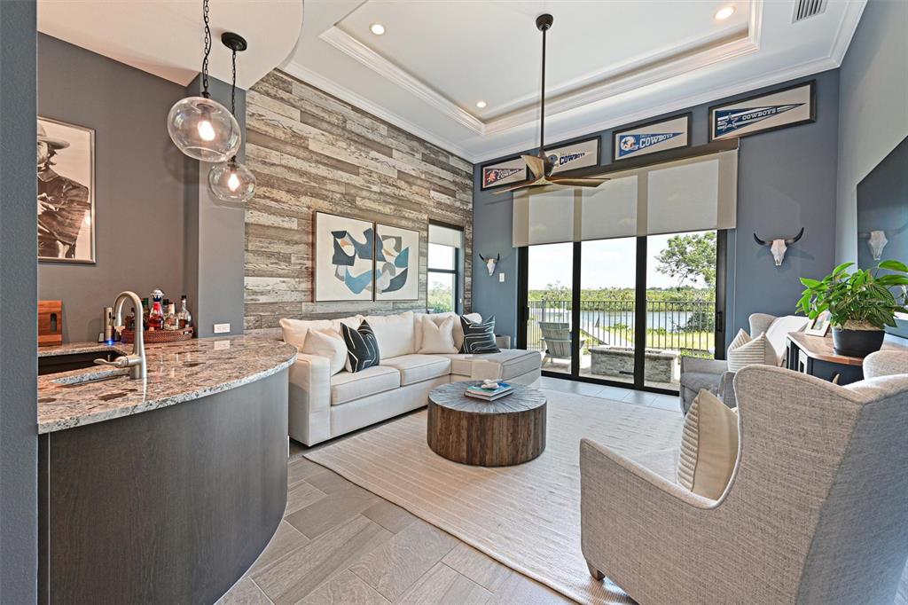 11807 Rive Isle Run Parrish, FL 34219 - Photo 20 of 57 a living room with furniture a chandelier and a flat screen tv