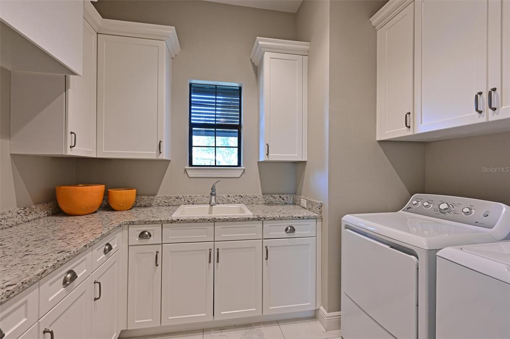 11807 Rive Isle Run Parrish, FL 34219 - Photo 26 of 57 a utility room with granite countertop cabinets washer and dryer