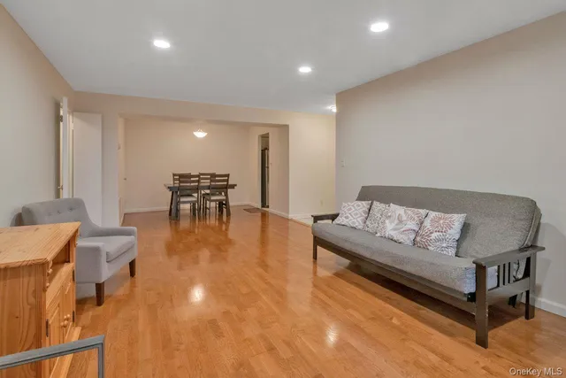 a living room with furniture and a dining table with wooden floor
