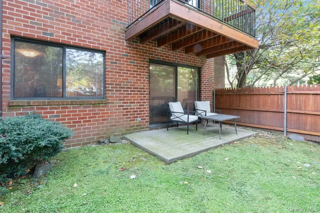 a view of backyard with a barbeque grill and wooden fence