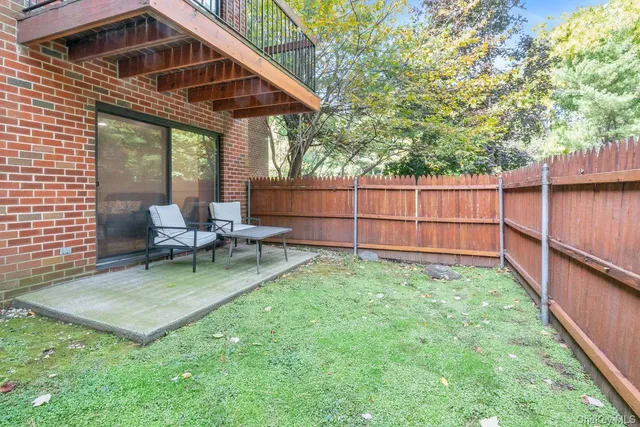 a view of a chair and table in backyard of the house