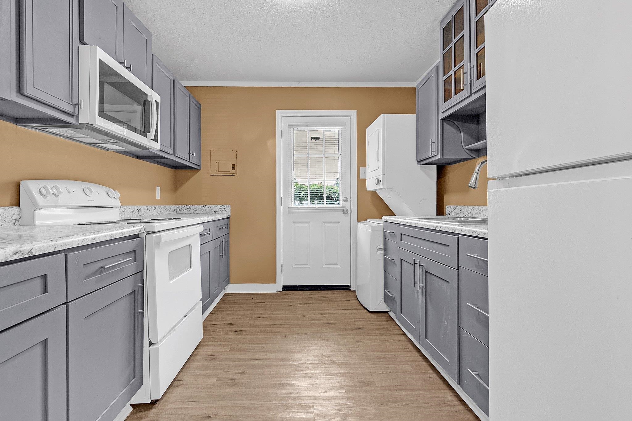 3186 Alta Road Memphis, TN 38109 - Photo 5 of 14 Kitchen featuring wood-finish flooring and a white exterior door