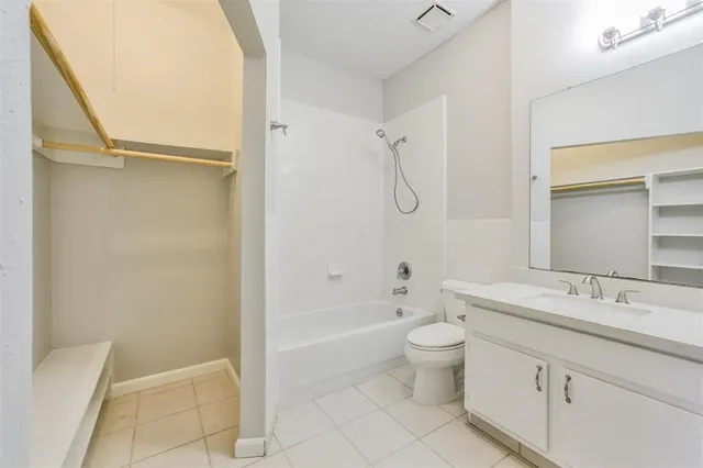 a bathroom with a granite countertop sink a toilet and shower
