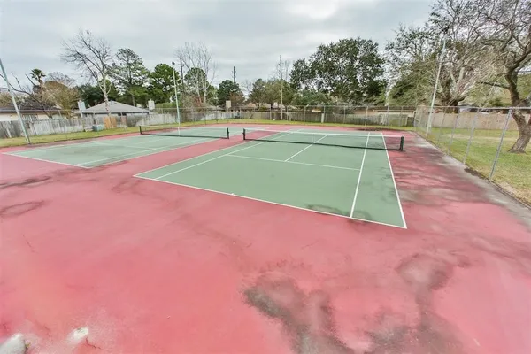 a tennis court with trees in the background