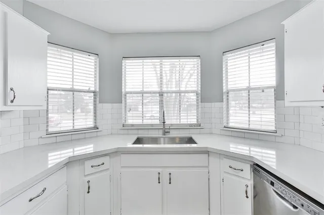 a kitchen with sink windows and cabinets