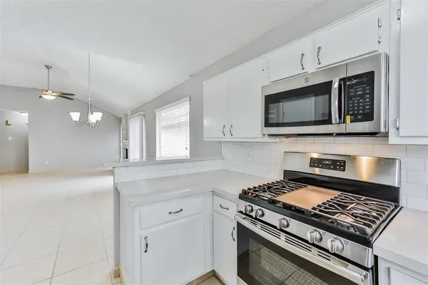 a kitchen with stainless steel appliances a stove a microwave and cabinets