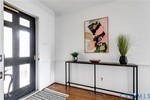 a view of a hallway with paintings on the wall and a potted plant