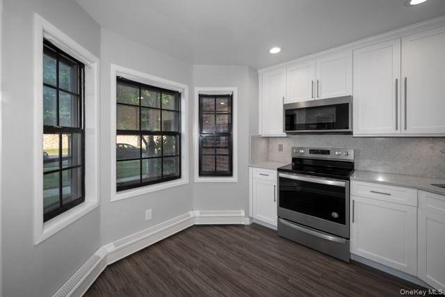 1593 August Road, Unit 1767 North Babylon, NY 11703 - Photo 3 of 10 a kitchen with granite countertop a stove and a microwave