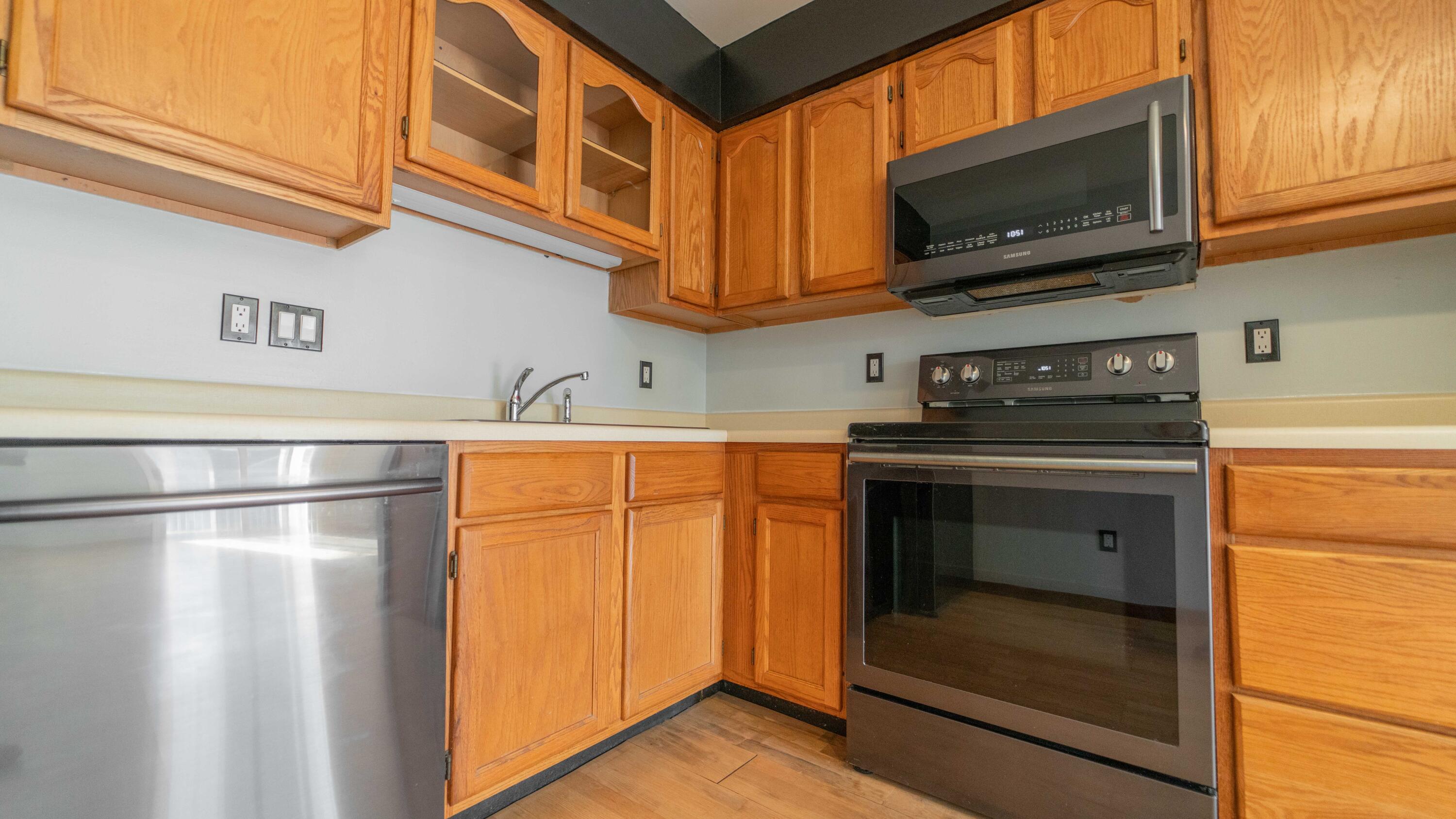 1069 Millpond Road, Unit E Valparaiso, IN 46385 - Photo 8 of 19 a kitchen with stainless steel appliances granite countertop a refrigerator a stove and a microwave