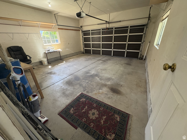 486 West 120 North Orem, UT 84057 - Photo 29 of 30 Spacious garage with an overhead sectional door, concrete flooring, and a single window