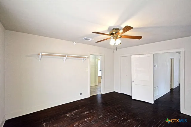 a view of an empty room with wooden floor