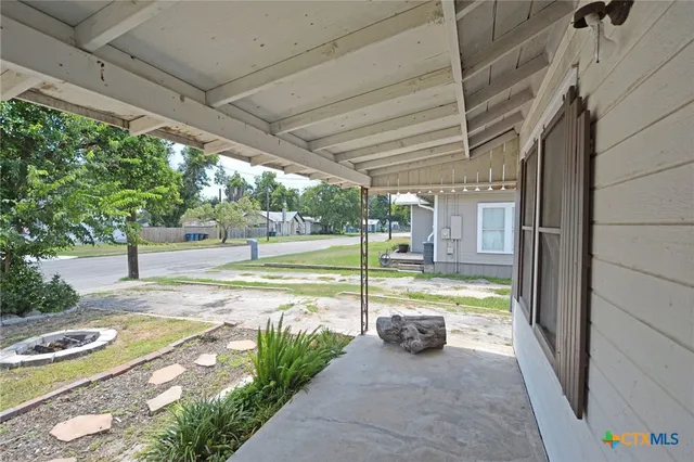 a view of a porch with furniture and garden