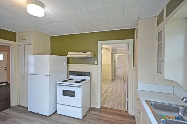 a kitchen with a refrigerator a stove top oven a sink and dishwasher