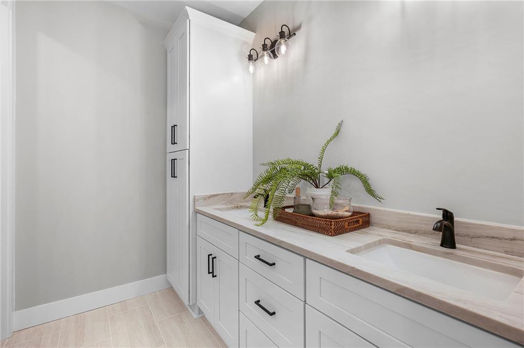 1783 4 Mile Church Road Ball Ground, GA 30107 - Photo 41 of 60 a bathroom with a sink a vanity and mirror