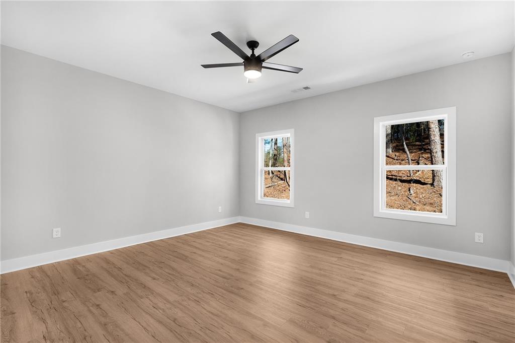 1783 4 Mile Church Road Ball Ground, GA 30107 - Photo 49 of 60 an empty room with wooden floor fan and windows