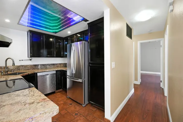 a kitchen with a refrigerator sink and wooden floor
