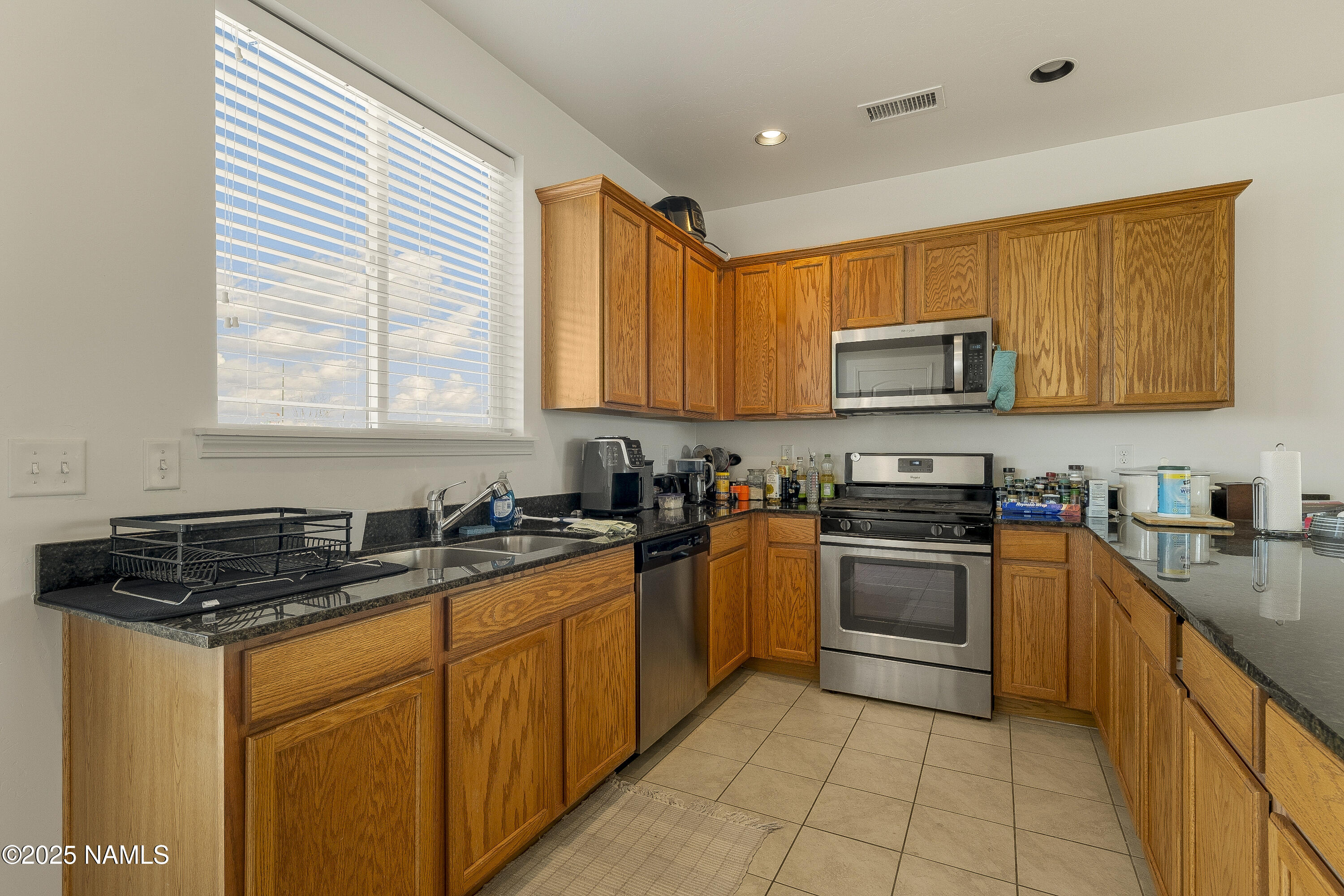 12361 Pegasus Road Bellemont, AZ 86015 - Photo 6 of 18 a kitchen with stainless steel appliances granite countertop a stove sink microwave and window