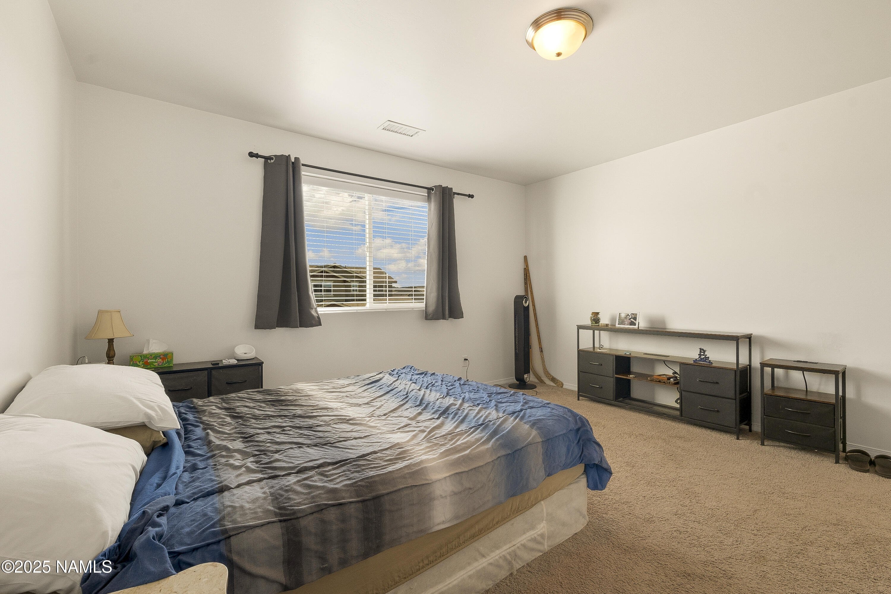 12361 Pegasus Road Bellemont, AZ 86015 - Photo 7 of 18 a bedroom with a bed and dresser with wooden floor