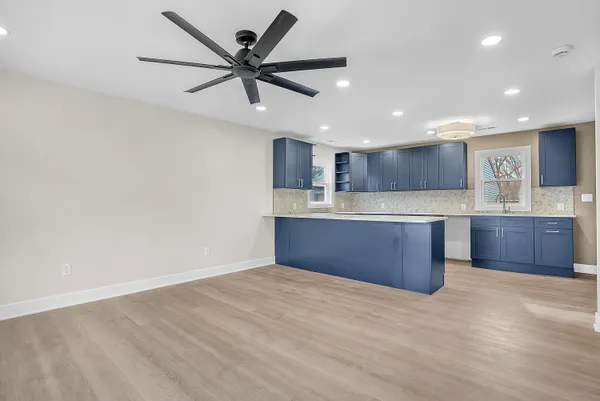 a open kitchen with kitchen island a sink stainless steel appliances and cabinets