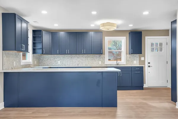 a kitchen with kitchen island granite countertop wooden cabinets a sink and dishwasher