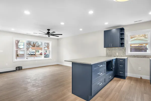 a kitchen with stainless steel appliances granite countertop a sink a stove and a wooden floors