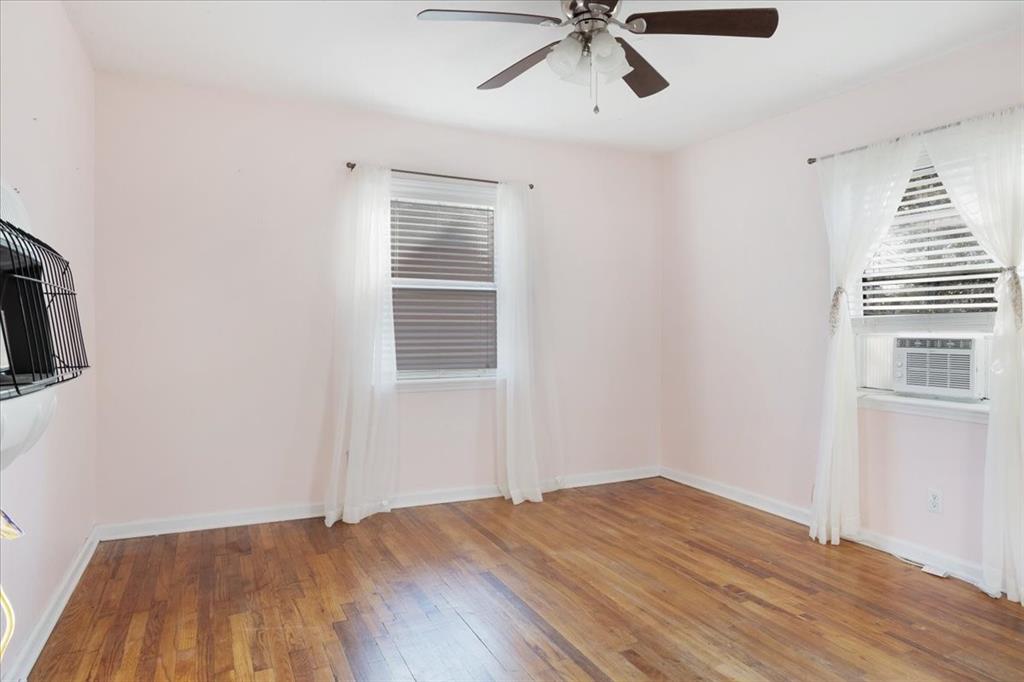 203 South Carter Street Whitewright, TX 75491 - Photo 6 of 18 Bedroom with light wood finished floors, a ceiling fan, and cooling unit