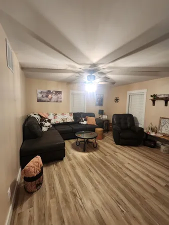 a living room with furniture a wooden floor and a fireplace