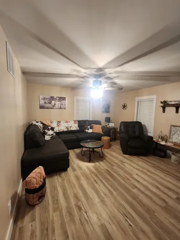 a living room with furniture a wooden floor and a fireplace