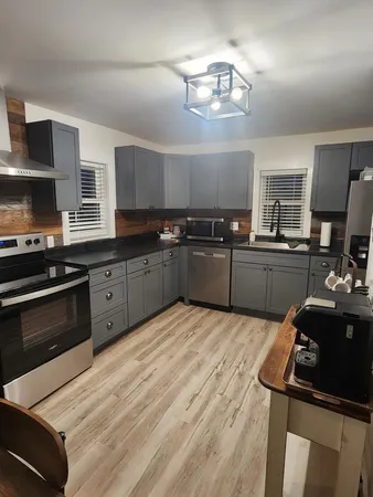 a kitchen with kitchen island stainless steel appliances a sink stove and refrigerator