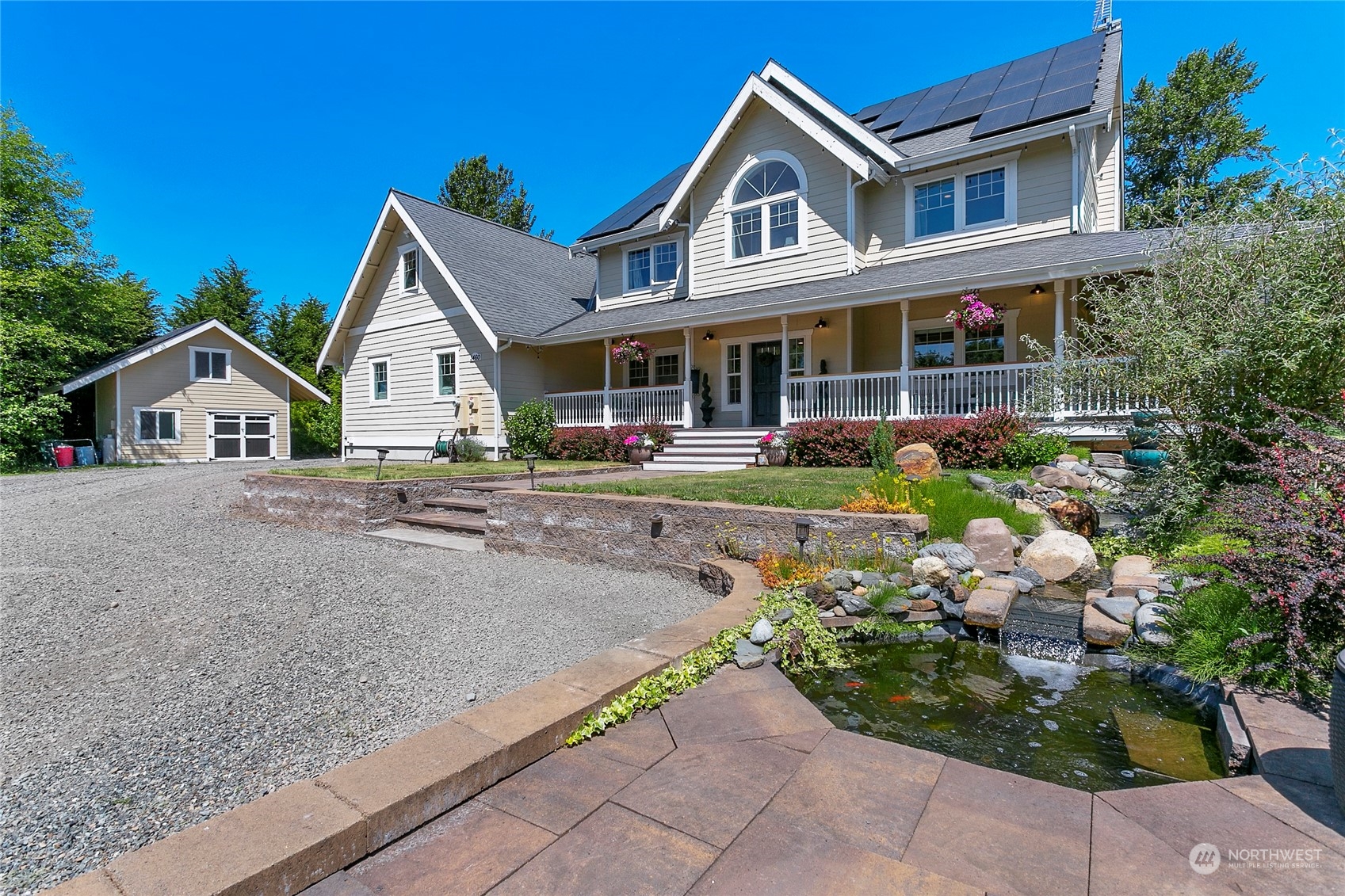 a view of a white house with a small yard and plants