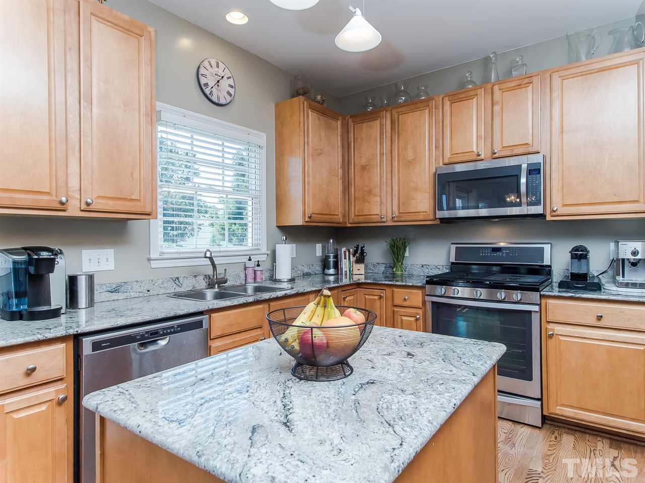 5108 Amberfield Way Raleigh, NC 27604 - Photo 8 of 23 a kitchen with stainless steel appliances granite countertop wooden cabinets a stove a sink and a microwave