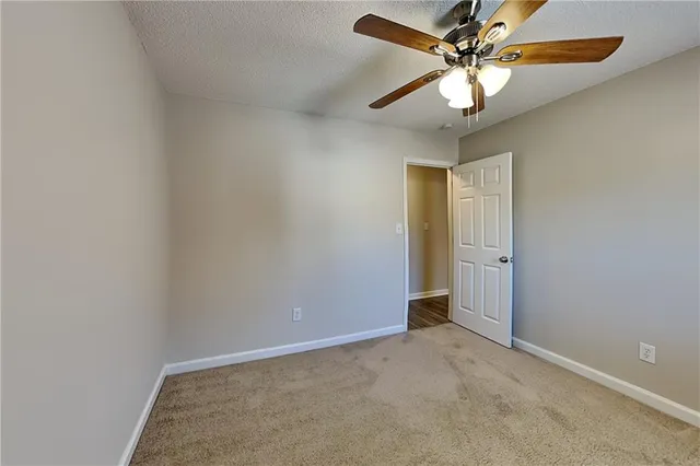 an empty room with a fan and a fan