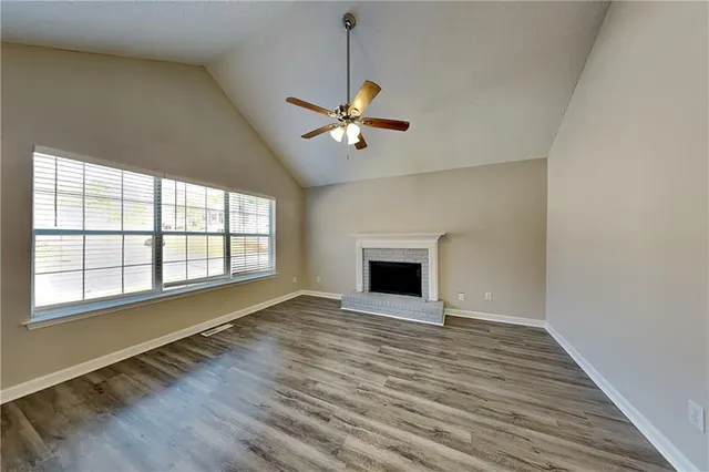 a view of an empty room with a fireplace and a window