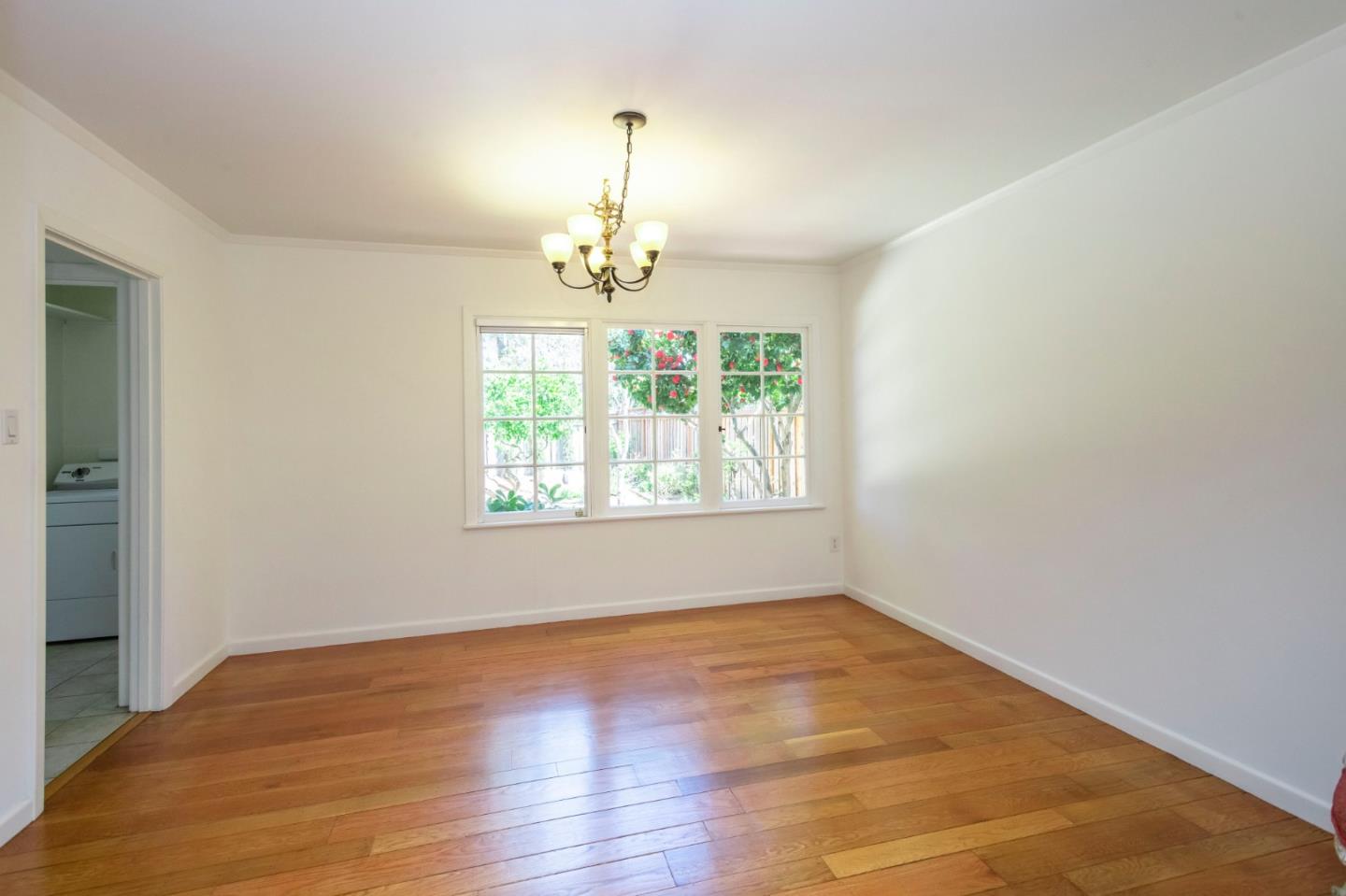 1556 Albemarle Way Burlingame, CA 94010 - Photo 7 of 18 an empty room with wooden floor chandelier and windows