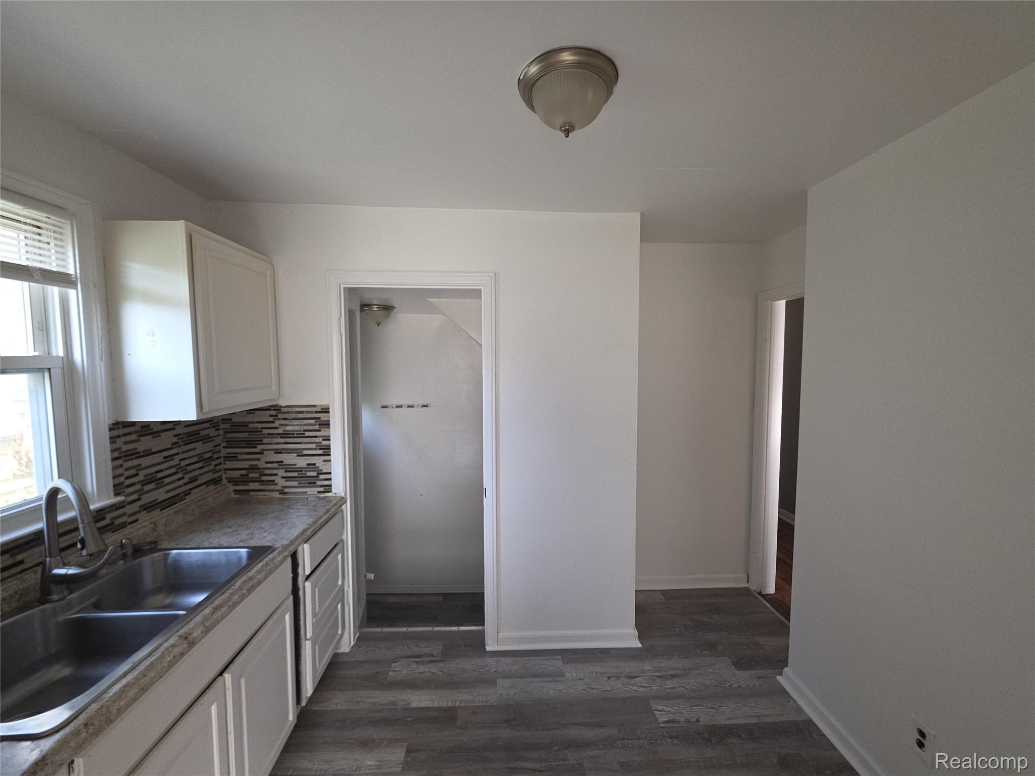 9025 Burt Road Detroit, MI 48228 - Photo 5 of 12 Kitchen featuring wood-finish flooring and white cabinetry
